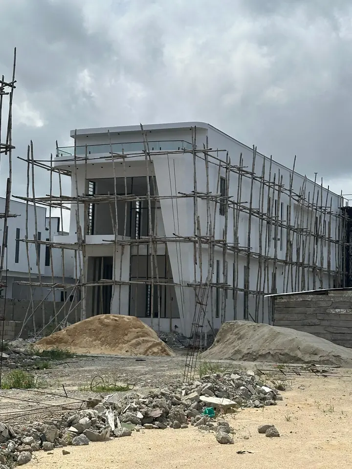 White rendered two-storey building with timber scaffolding in front